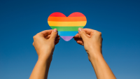 Hands holding rainbow heart.